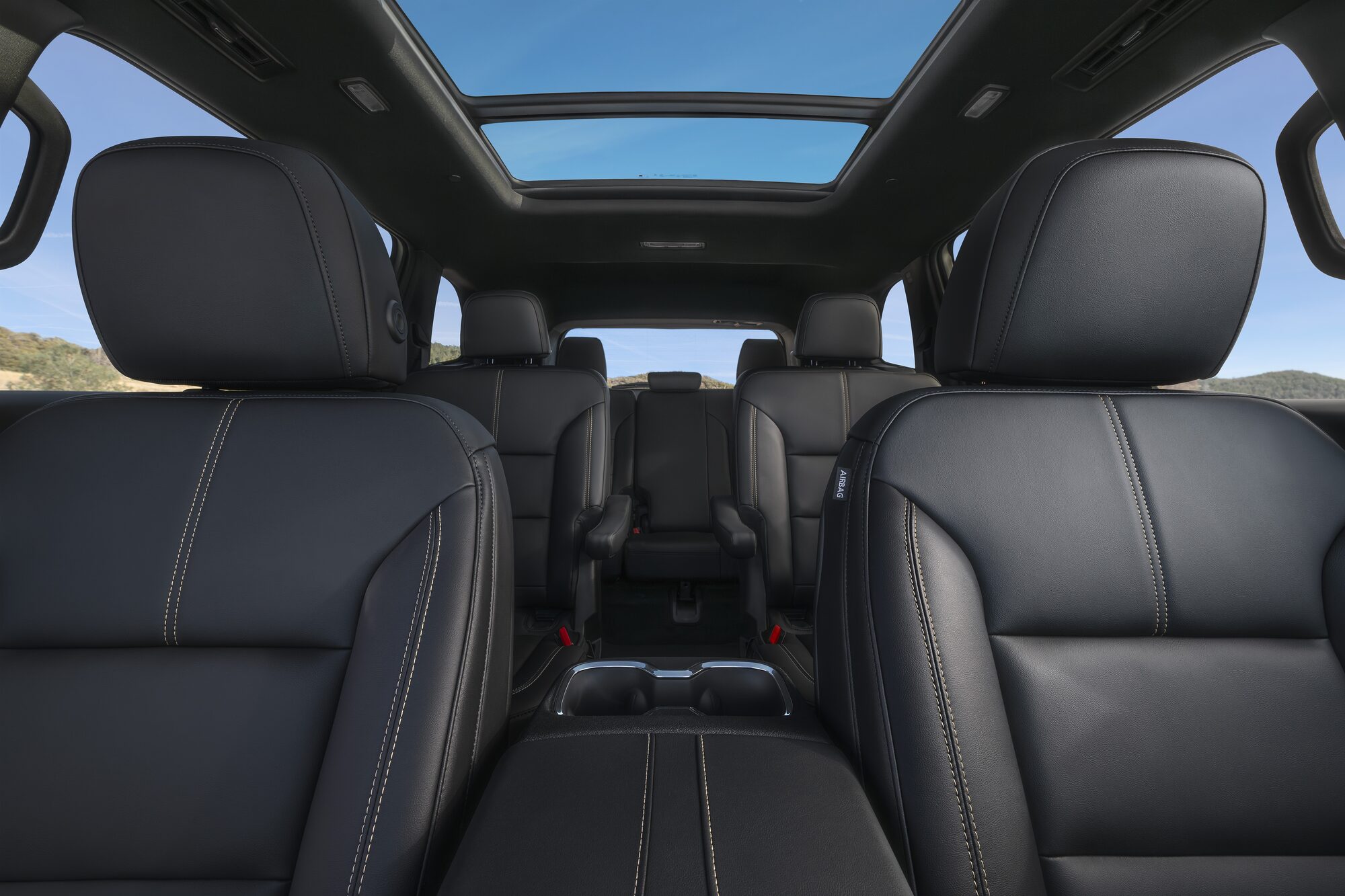 Black Leather Seats in the Interior of a GMC Vehicle with a Panoramic Sunroof