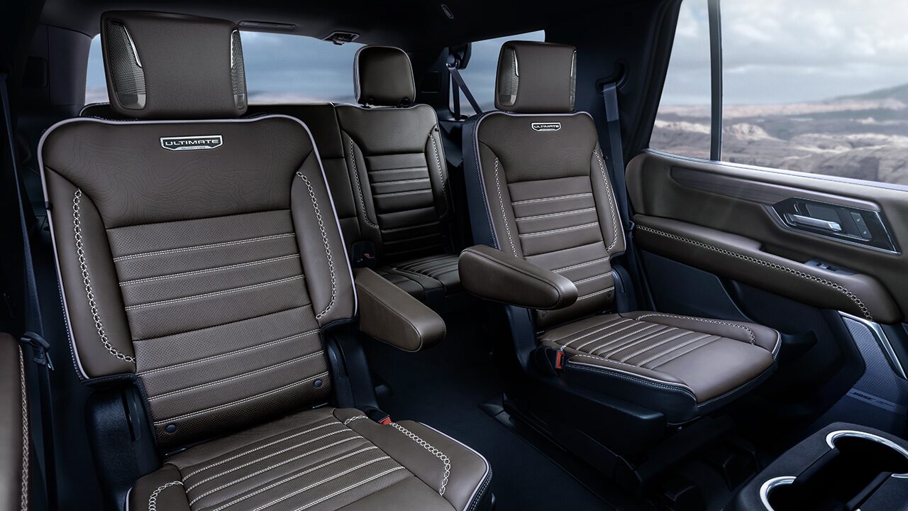 Brown Leather Interior Seats with White Stitching and Ultimate Branding in a GMC Vehicle with a Rocky Landscape Outside