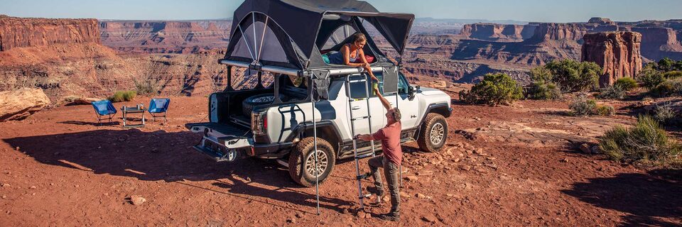 2021 GMC Yukon Denali driving on two-lane road through rugged terrain