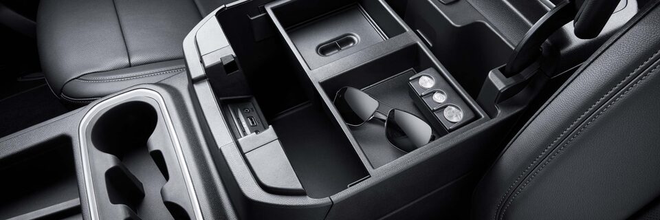 A View of the Interior Storage Space with a Pair of Glasses inside and coins on a GMC Vehicle