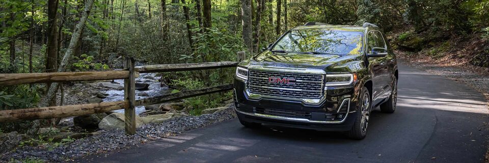 A GMC Acadia Denali SUV Driving on a Path Surrounded by Trees
