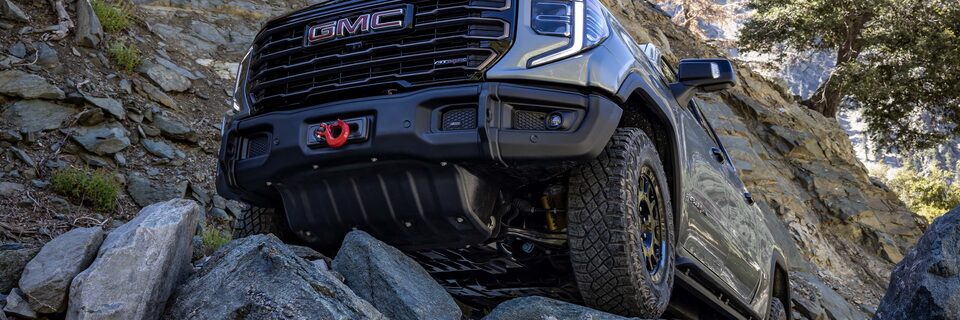 The GMC Sierra AT4X AEV Off-Road Truck Driving Over Rough Terrain