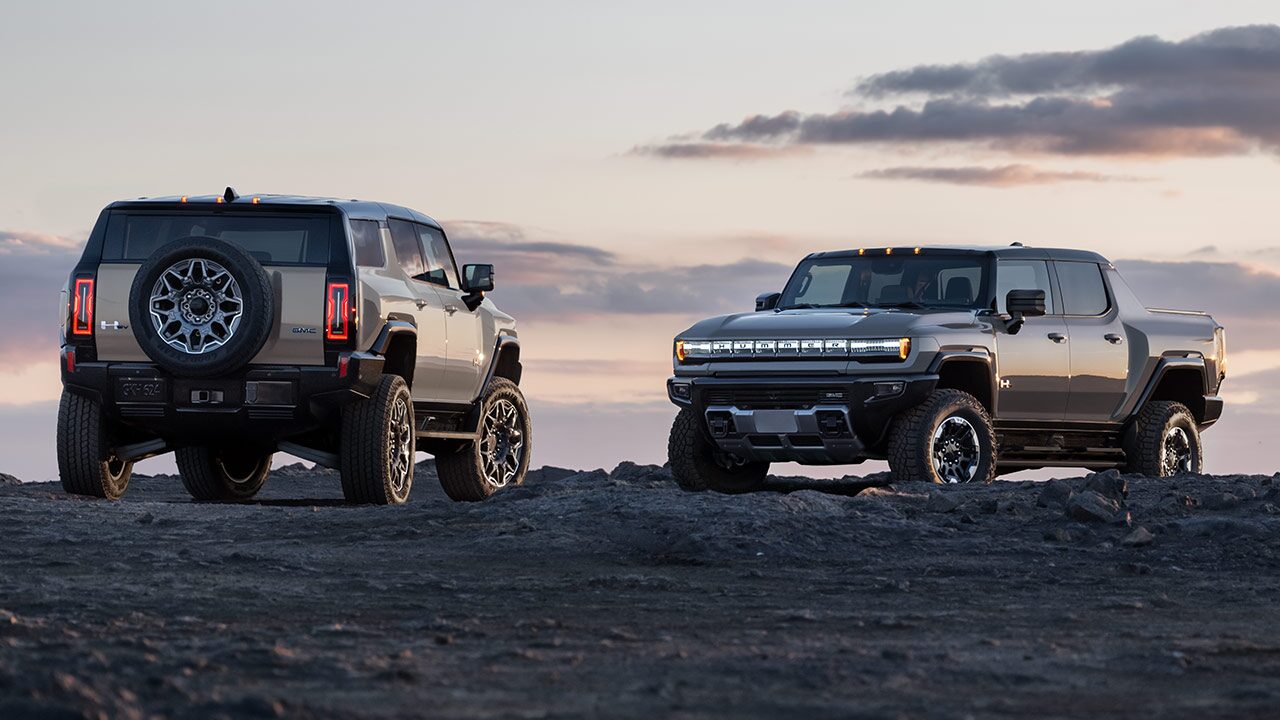 The GMC HUMMER EV SUV and The HUMMER EV Pickup Truck Parked Off-Road as the Sunsets