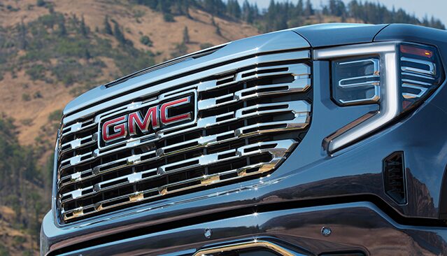 A Close-Up Front View of the Chrome Grille and Red GMC Logo on a GMC Sierra Pickup Truck