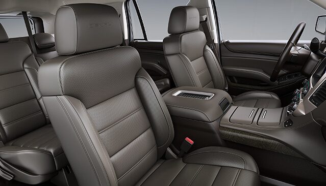 The Brown Leather Interior of a GMC Yukon Denali With Perforated Seats and a Center Console