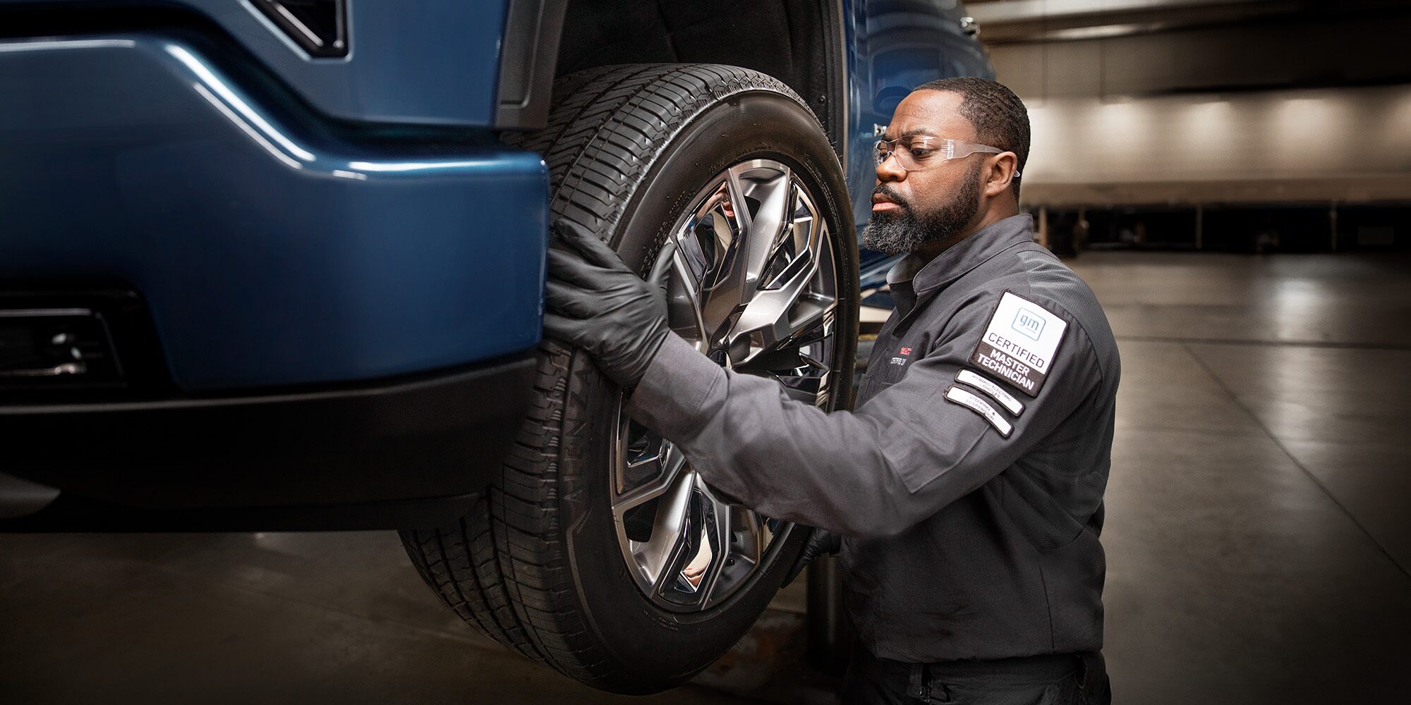 A Mechanic Wearing Safety Glasses Inspecting the Break of a Wheel inside a Vehicle