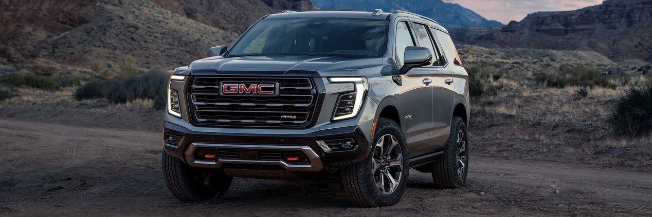 Front Three-Quarter View of the GMC Yukon Large SUV Parked in the Desert at Sunset
