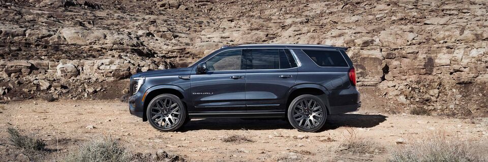Profile View of the GMC Yukon Large SUV Parked in the Desert on Rough Terrain