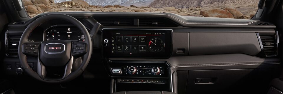 Wide View of the Dashboard, Infotainment System, and Steering Wheel in a 2025 GMC Sierra HD AT4 Truck