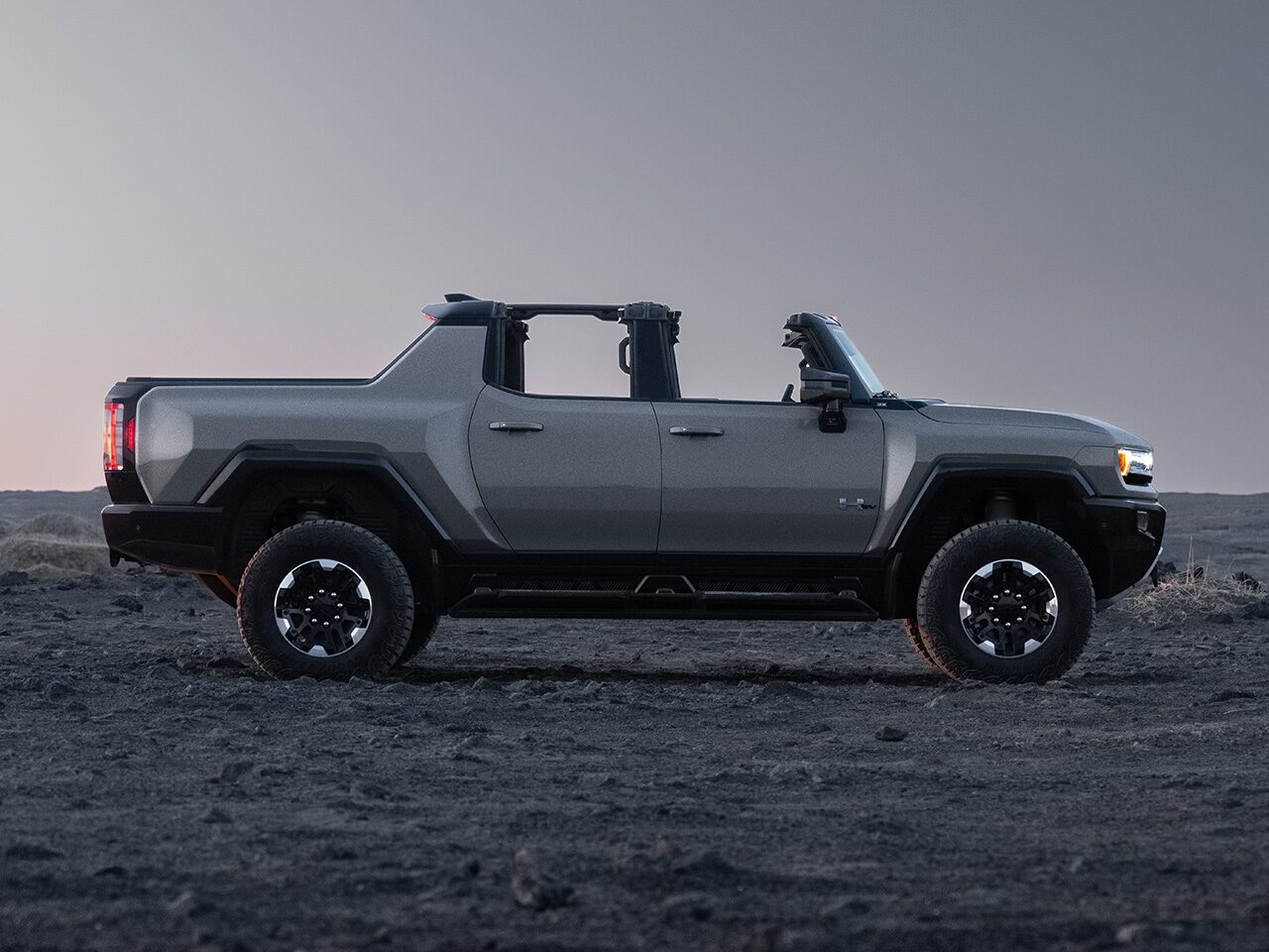 Passenger Side View of the 2026 GMC HUMMER EV Pickup Truck Parked in a Rocky Desert