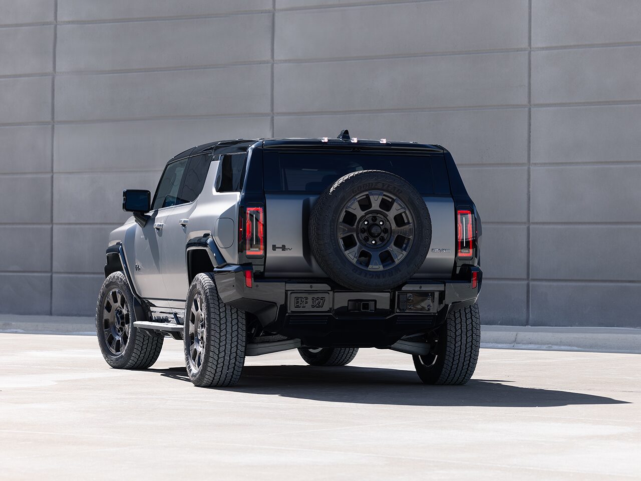 Rear End View of the 2026 GMC HUMMER EV SUV Parked by a Concrete Wall