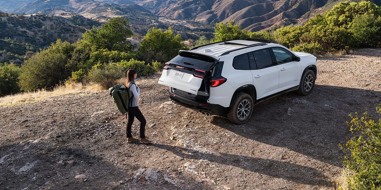 Exterior View of the 2026 GMC Acadia Mid-Size SUV Towing a Trailer