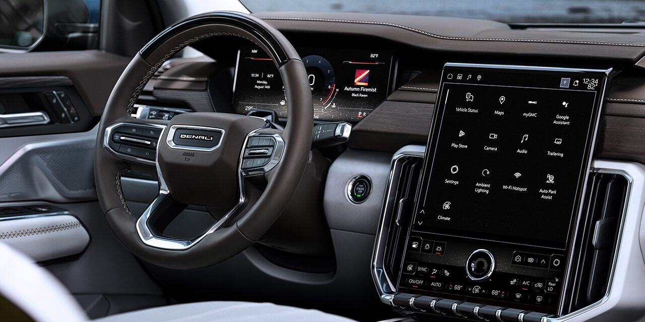 Interior Close-up View of the Steering Wheel and Infotainment System in the GMC Acadia Denali Luxury Mid-Size SUV
