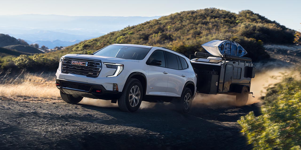 Exterior View of the 2026 GMC Acadia Mid-Size SUV Towing a Trailer