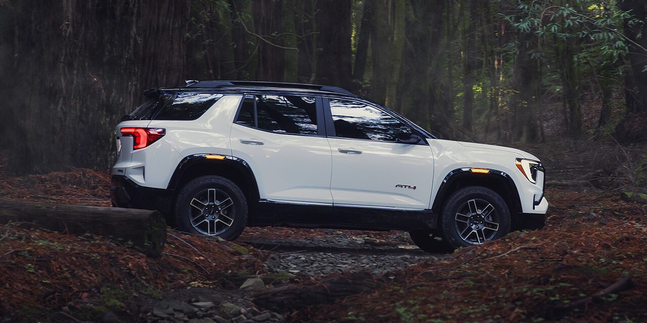 Profile View of the 2026 GMC Terrain AT4 Small Off-Road SUV Driving Through the Forest