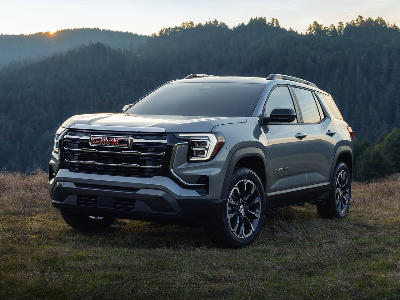 Front Three-Quarters Exterior View of the 2026 GMC Terrain Elevation Small SUV Parked in a Grassy Field